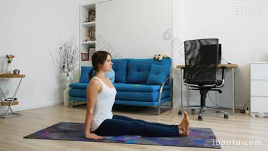 Young woman practicing yoga at home, sits in inversion position